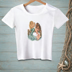 White t-shirt graphic featuring two mermaids sitting on a wooden dock looking in a mirror.