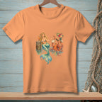 Orange t-shirt with a mermaid and octopus by a wooden post in the water.