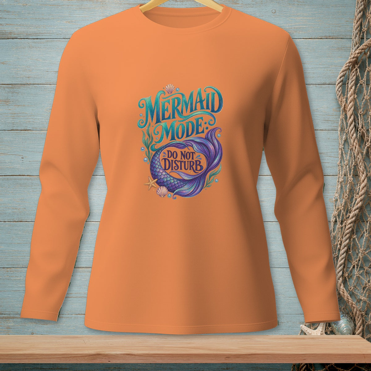 Orange long-sleeve shirt with "Mermaid Mode: Do Not Disturb" text and mermaid tail graphic.
