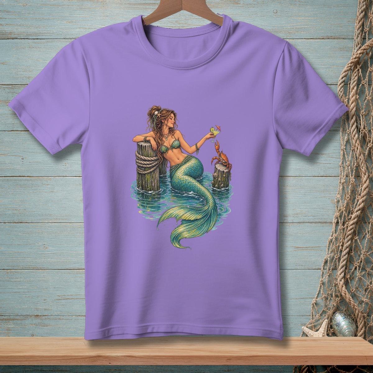 Purple t-shirt with a graphic of a mermaid and a crab by a dock.