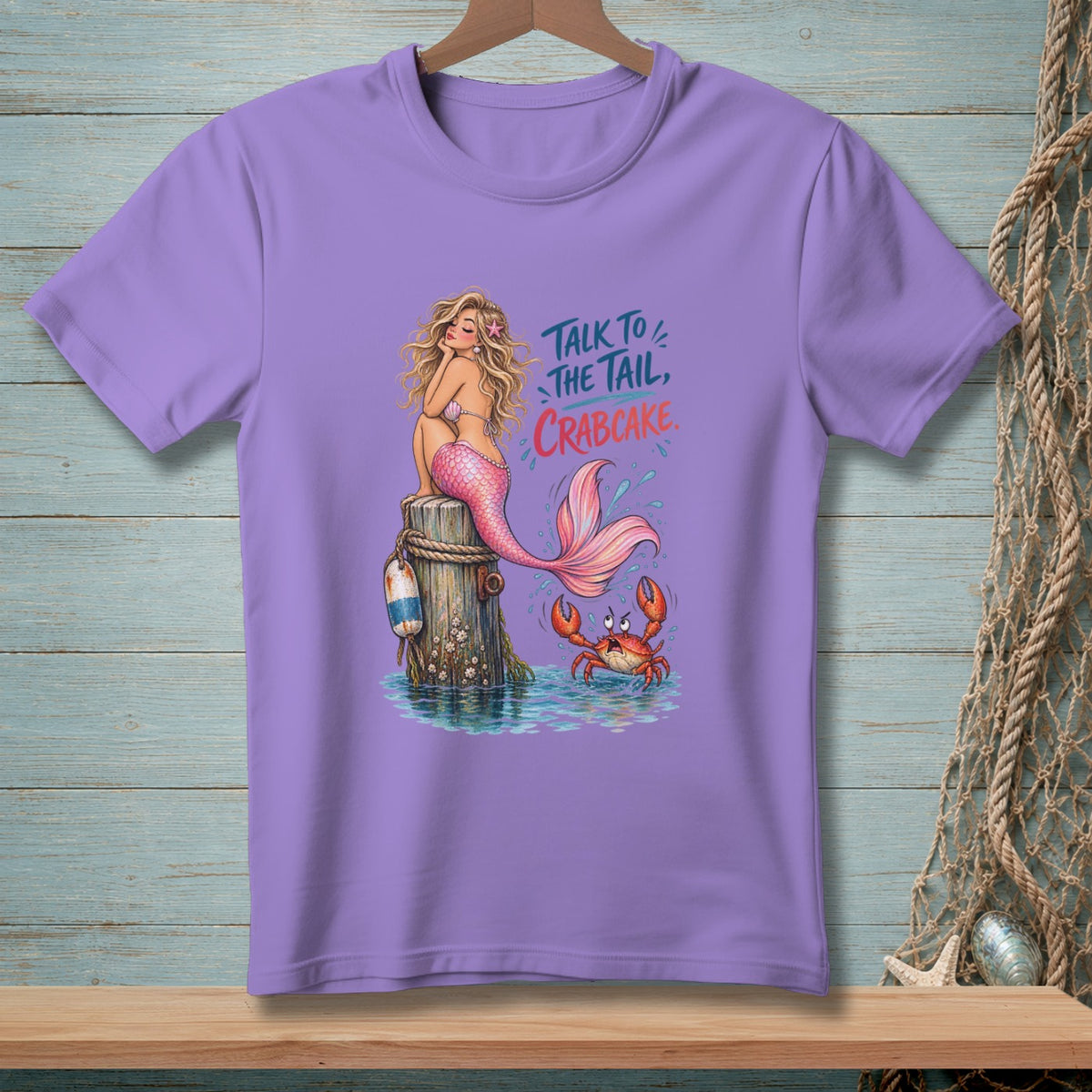 Mermaid and crab graphic with text "Talk to the tail, crabcake" on purple t-shirt.