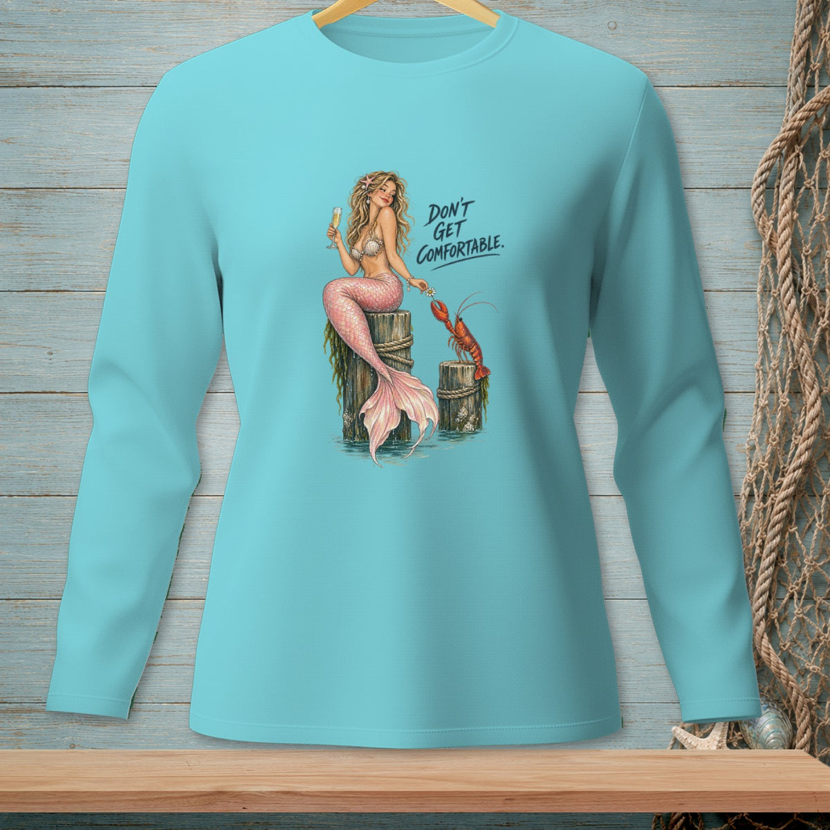 Mermaid with champagne and lobster on pilings, text "DON'T GET COMFORTABLE."
