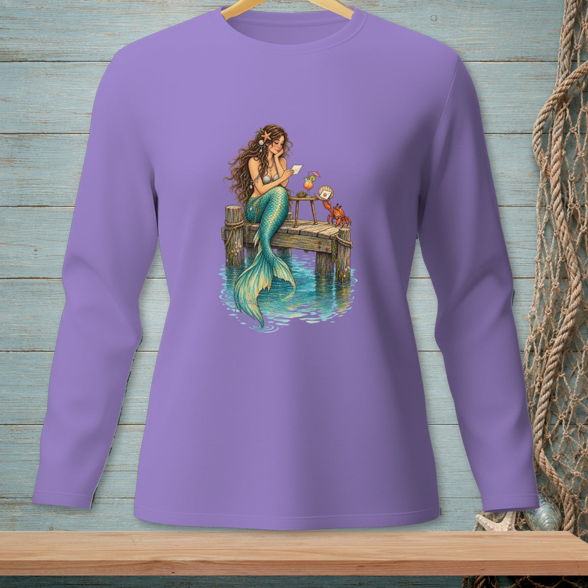 Mermaid reading on dock with drinks and crab, printed on a purple long-sleeve shirt.