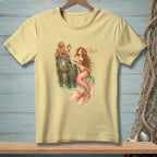 Light yellow t-shirt featuring mermaid and octopus with text "AS EXPECTED".