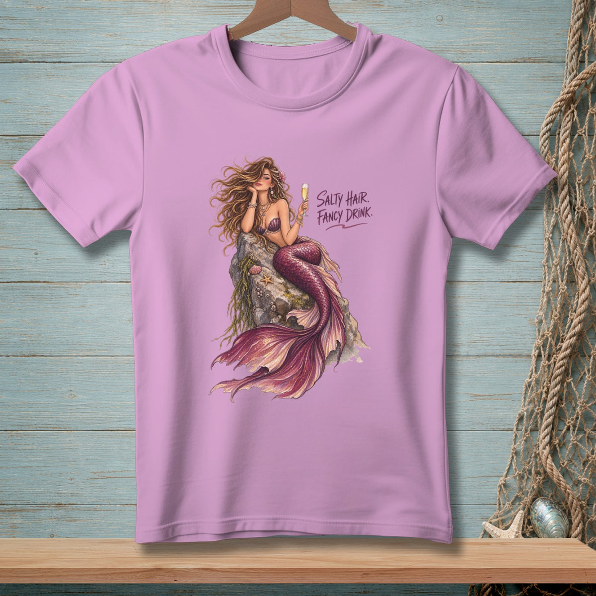 Pink t-shirt with a mermaid illustration and "Salty Hair. Fancy Drink." text.