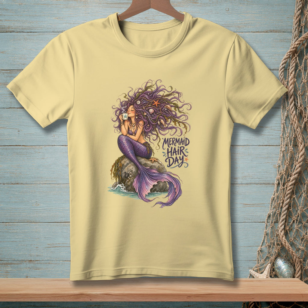 Light yellow t-shirt with a mermaid illustration holding a mug and text "Mermaid Hair Day".