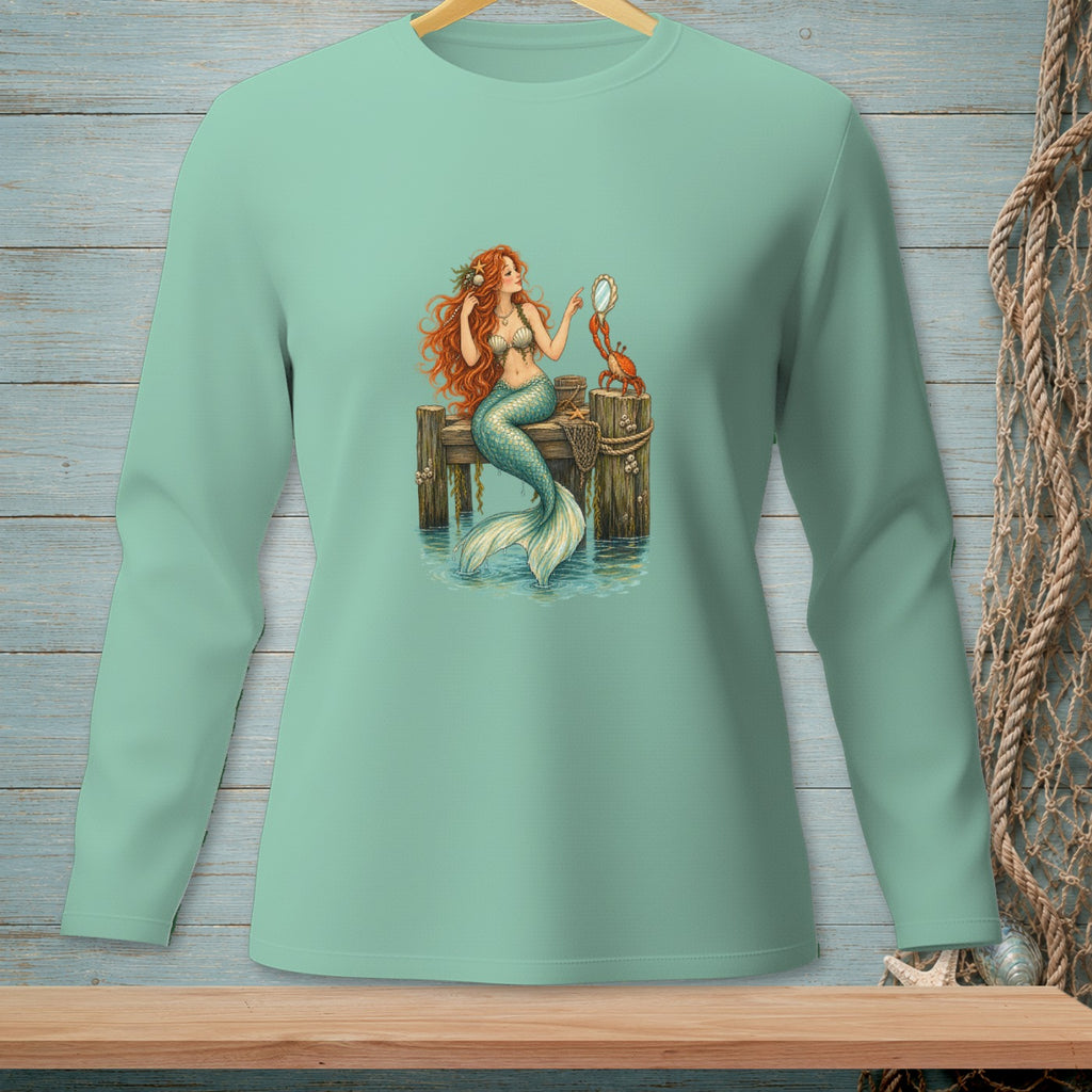 Mermaid with red hair combing her tail on a dock with a crab holding a mirror.