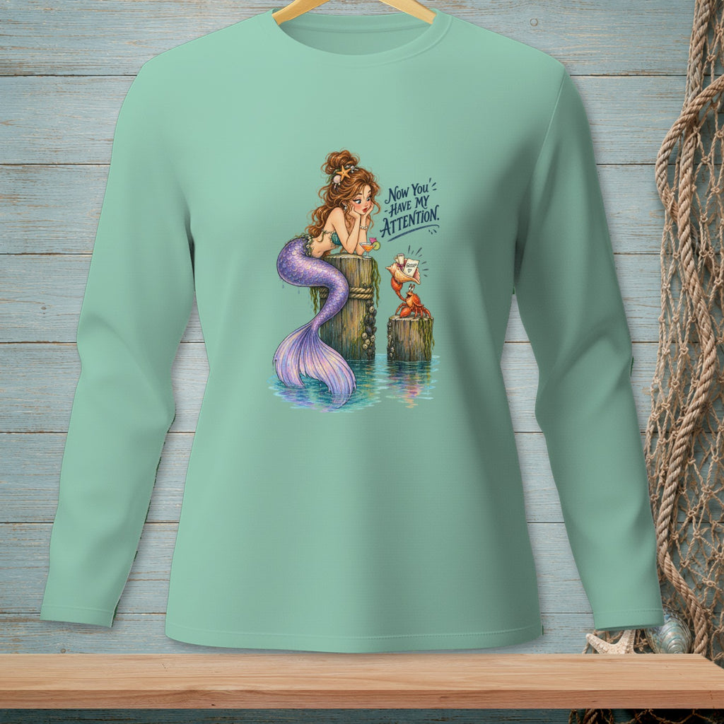 Mermaid sitting on a post next to a crab holding gossip, with text "Now You Have My Attention".