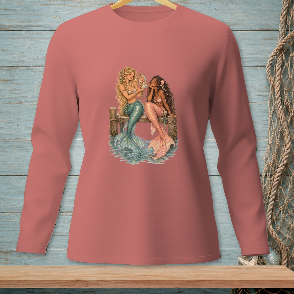 Two mermaids sit on a dock, one holding a seashell to her ear.