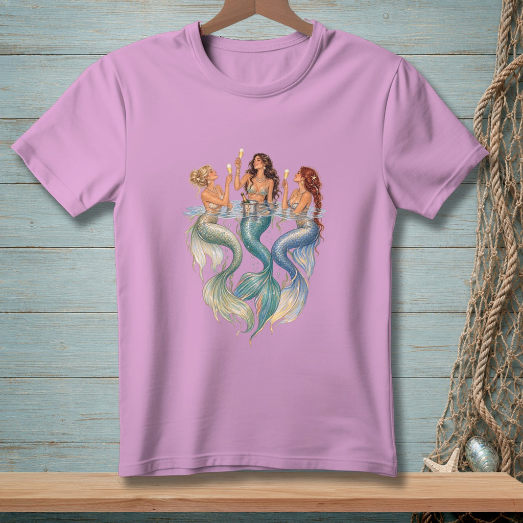 Three mermaids with tails in water, holding drinks on a pink t-shirt.