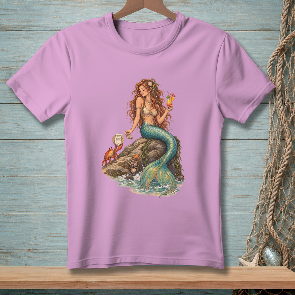 Pink t-shirt with a print of a mermaid holding a drink, sitting on a rock with a crab.