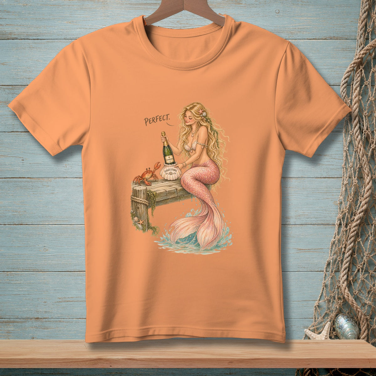 Orange t-shirt with mermaid, champagne, and crab on a pier.