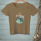 Brown t-shirt with a graphic of a mermaid sitting on a dock near water.