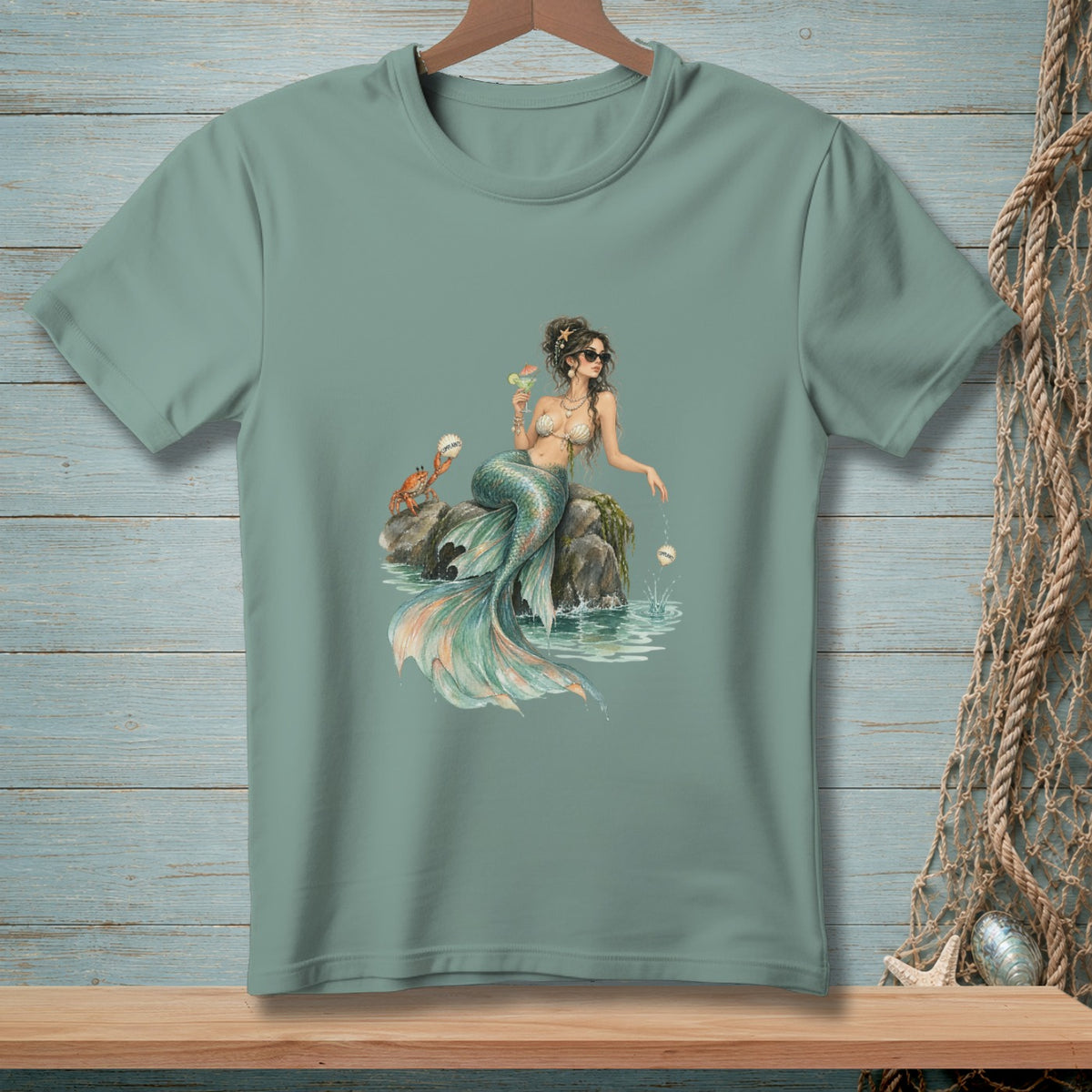 T-shirt with a mermaid holding a drink next to a crab and a pearl.