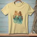 Two mermaids with blue tails sit on a dock, holding drinks.
