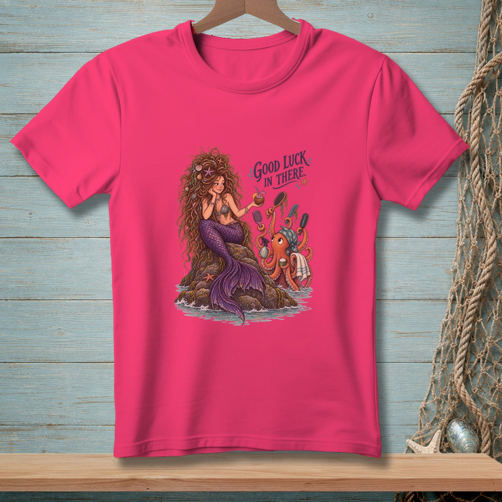 Pink t-shirt with a mermaid on a rock and an octopus with grooming tools.