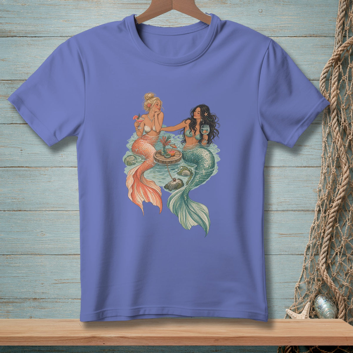 Two mermaids sit in water, one holding a cocktail, the other a wine glass.