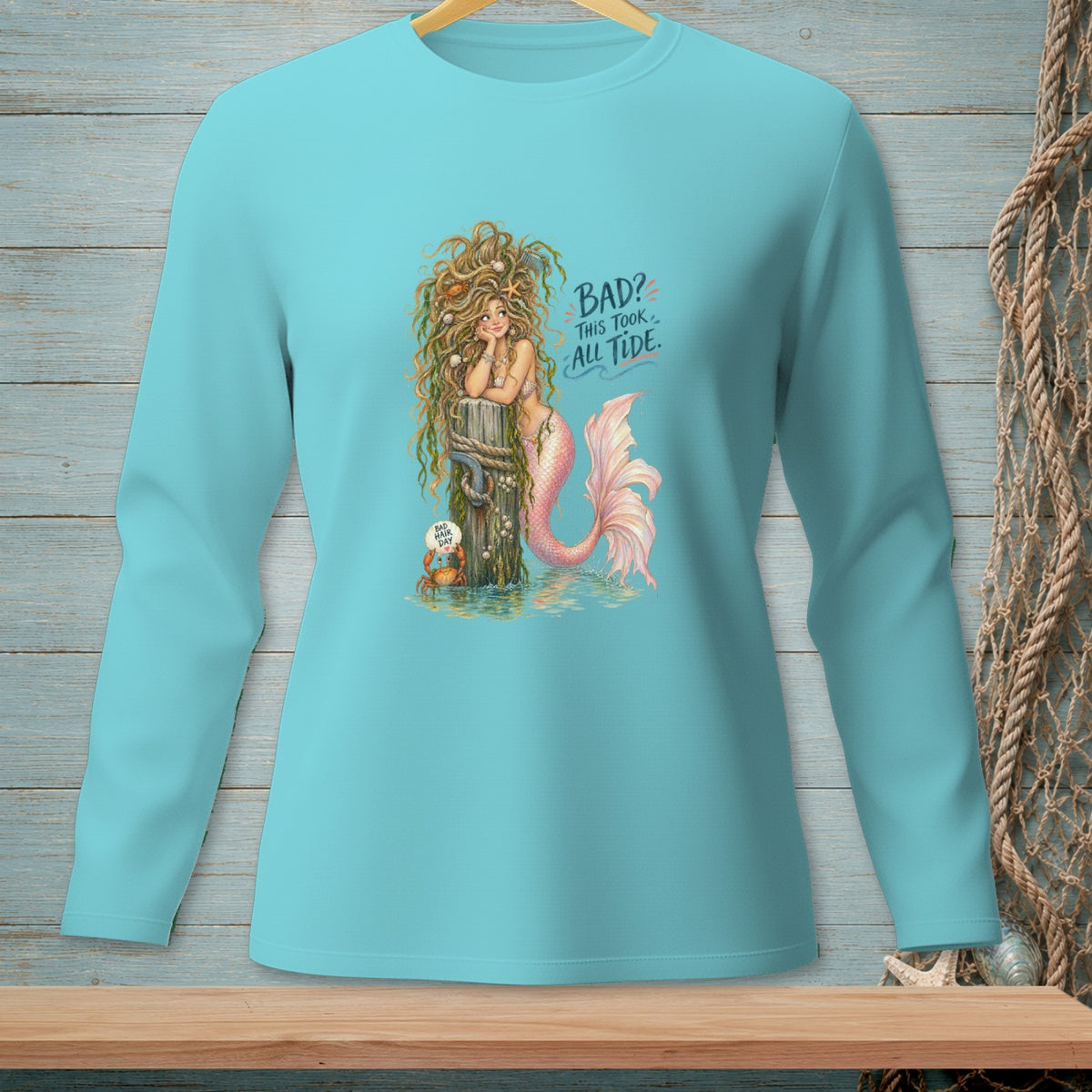 Turquoise long-sleeve shirt with a mermaid illustration and text "BAD? THIS TOOK ALL TIDE."