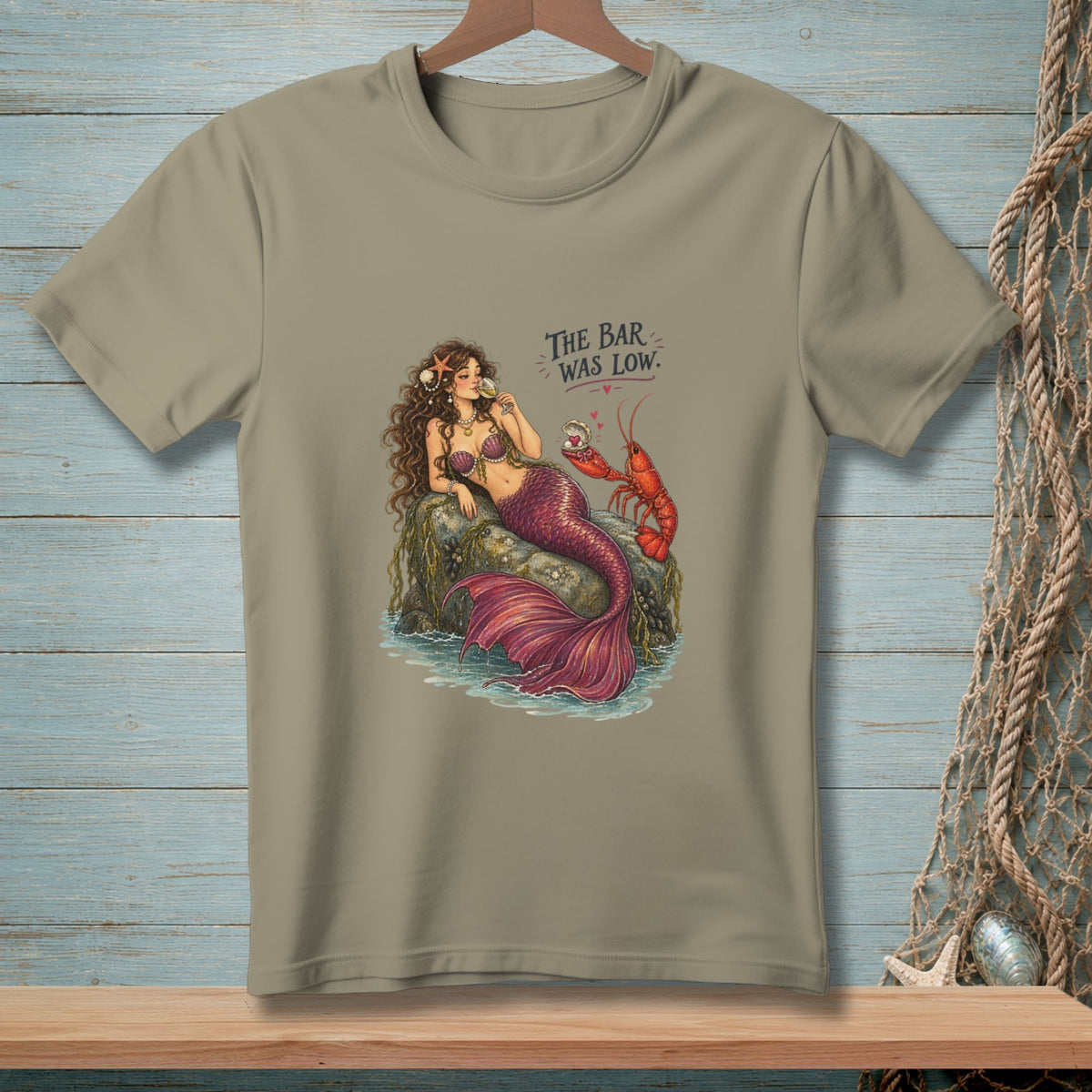 T-shirt with mermaid and lobster illustration and text "The Bar Was Low."