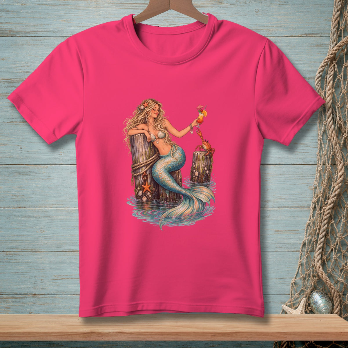 Pink t-shirt with mermaid holding a cocktail, a crab on a post.