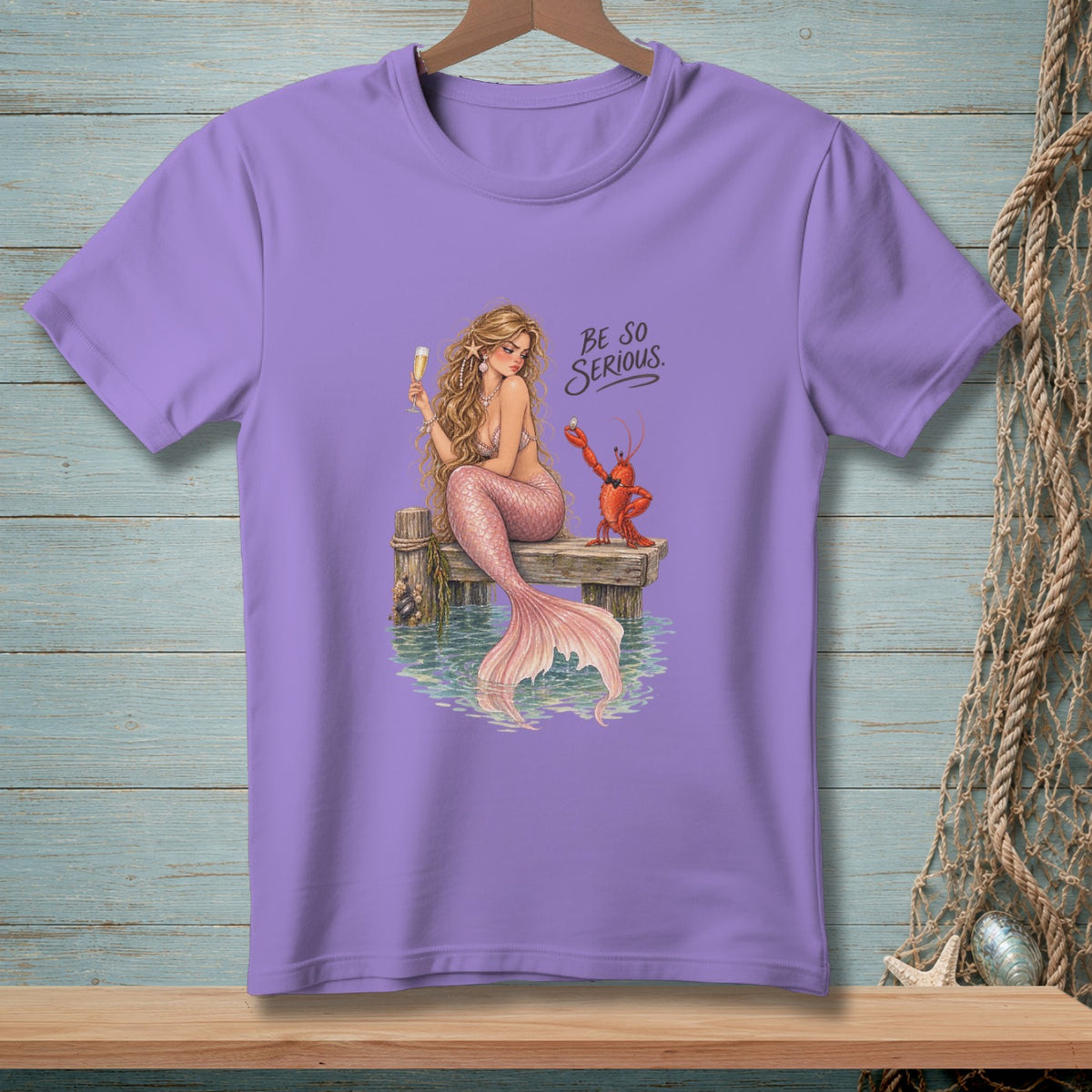 Purple t-shirt with a mermaid and lobster graphic and "Be So Serious" text.