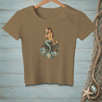 Brown t-shirt with a mermaid sitting on a rock holding a seashell.