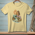 Two mermaids sit on rocks, one holding a pearl, with a basket nearby.