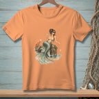 Orange t-shirt with illustration of mermaid, crab, and drink on rocks by water.
