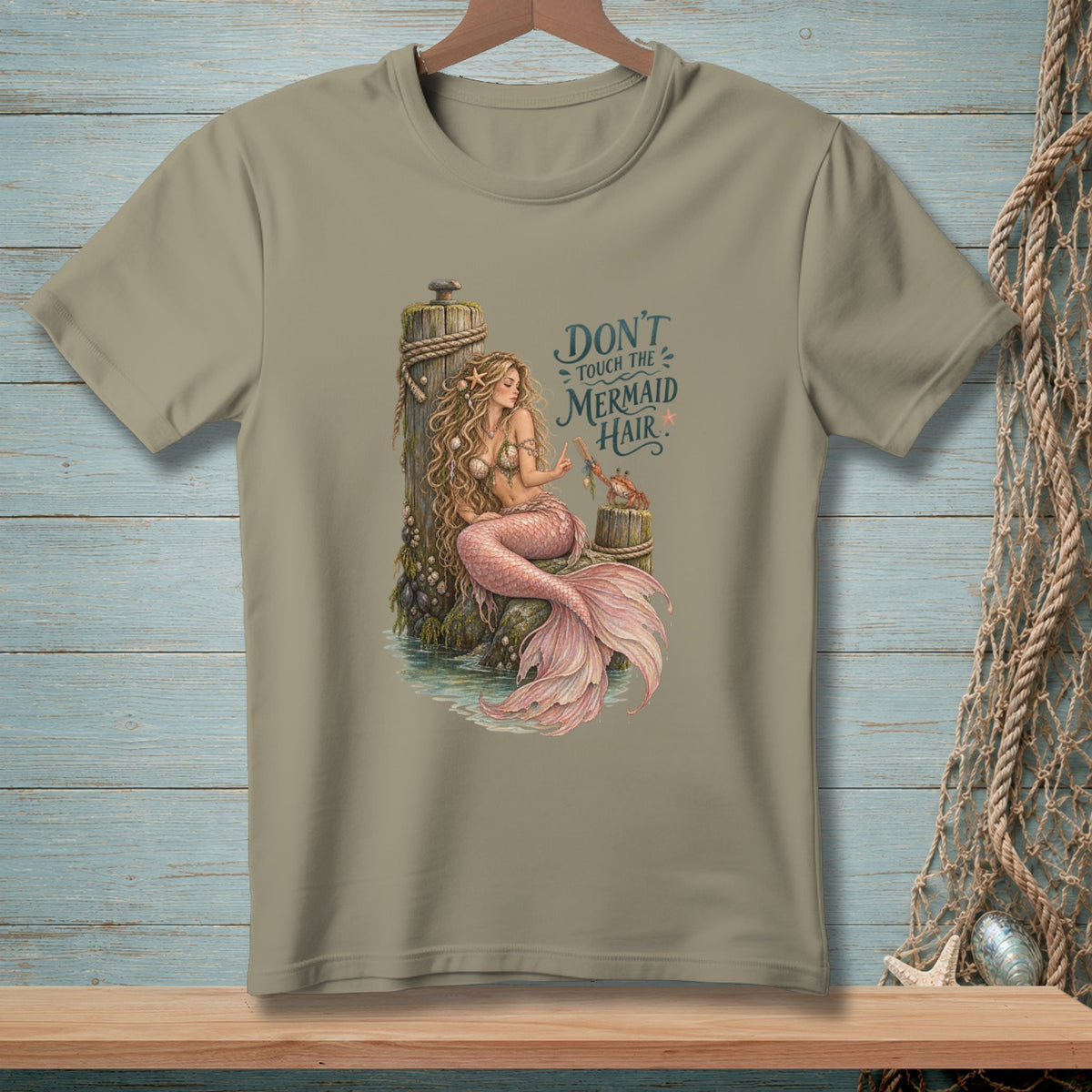 T-shirt graphic with mermaid sitting on a post, text reads "Don't touch the mermaid hair."