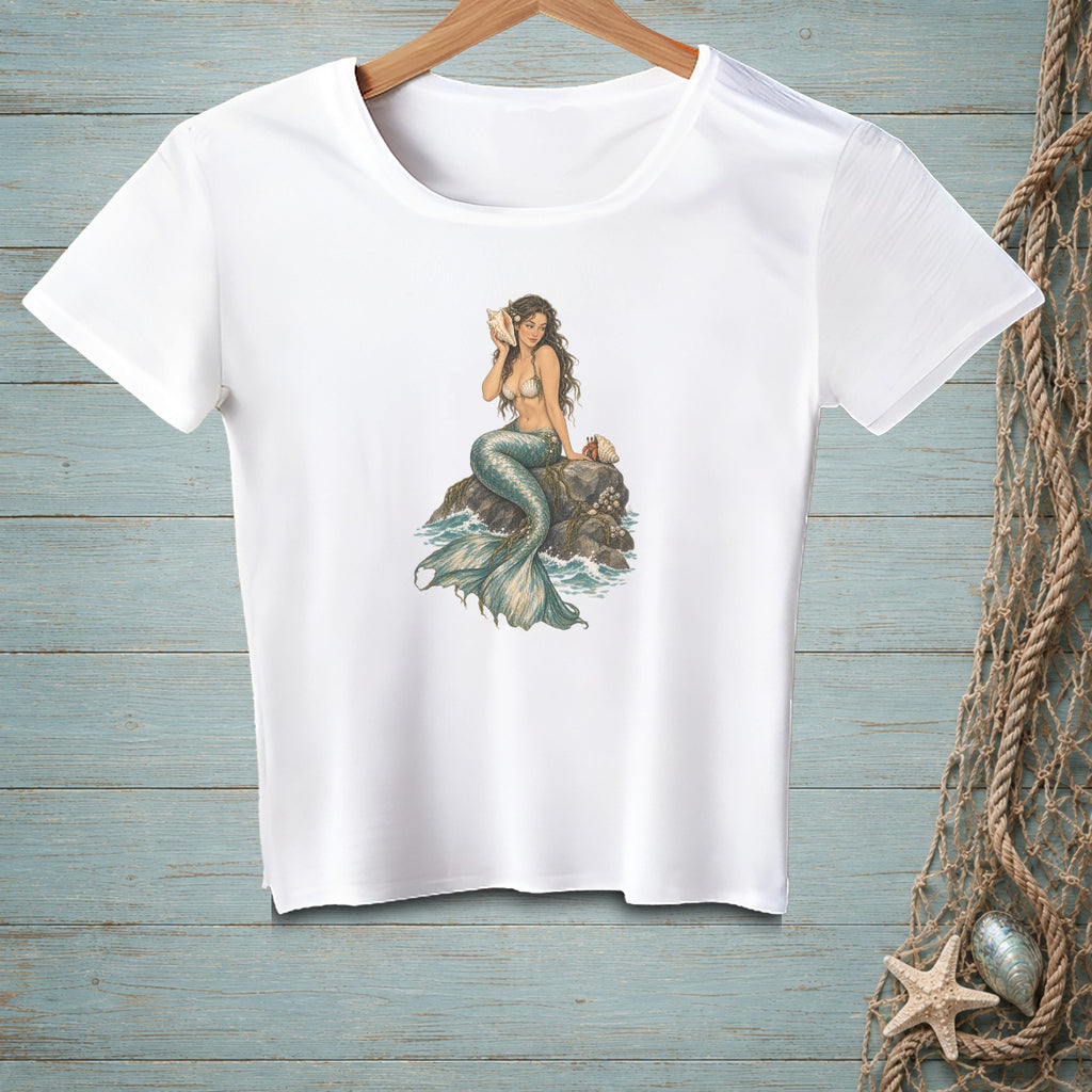 White t-shirt with a mermaid sitting on a rock, holding a seashell.