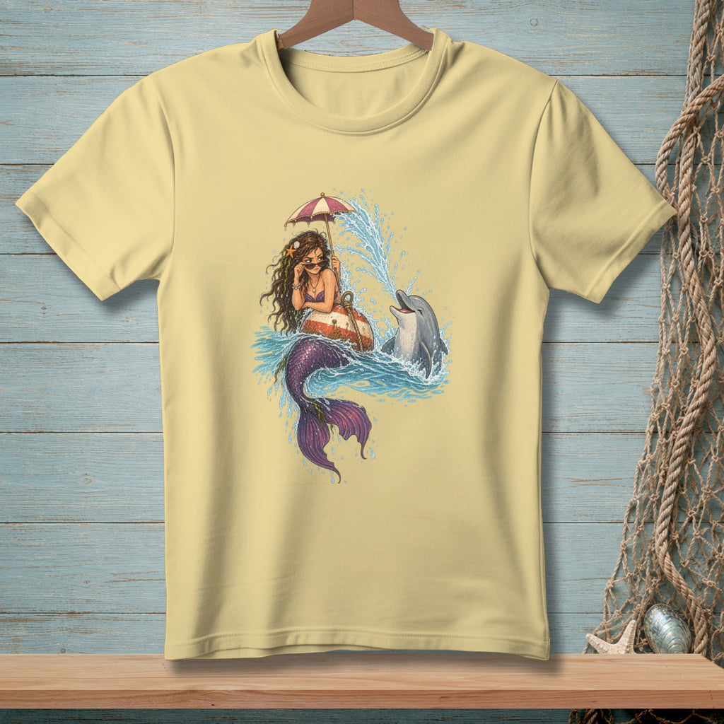 Mermaid with umbrella and dolphin splashing in water on light yellow t-shirt.