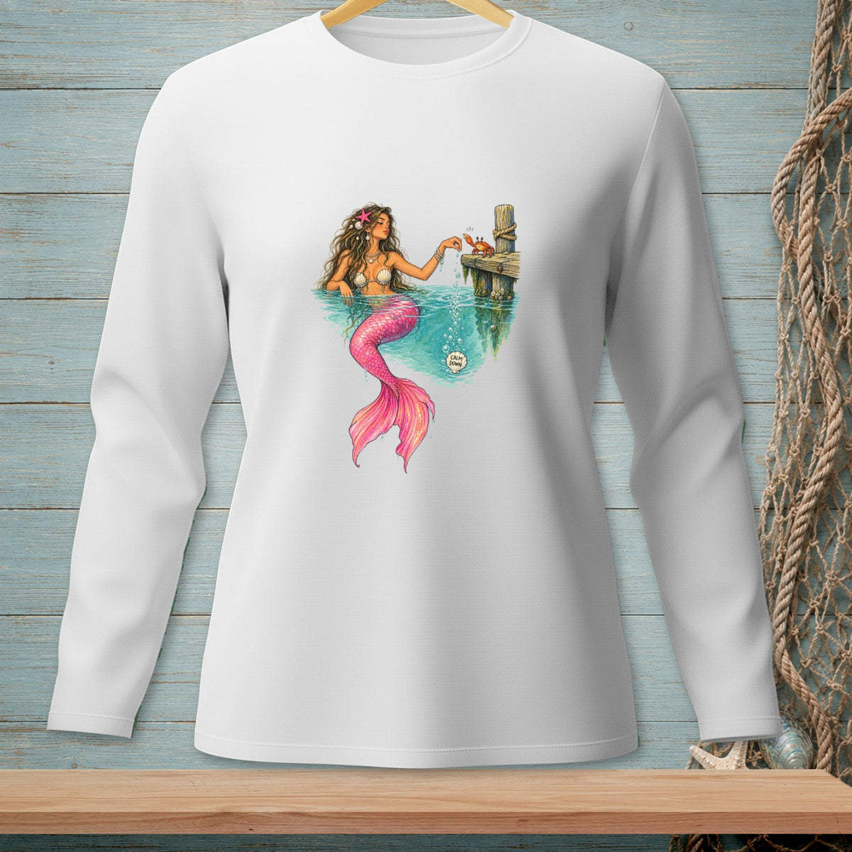 Illustration of a mermaid with pink tail on a white long-sleeve shirt.