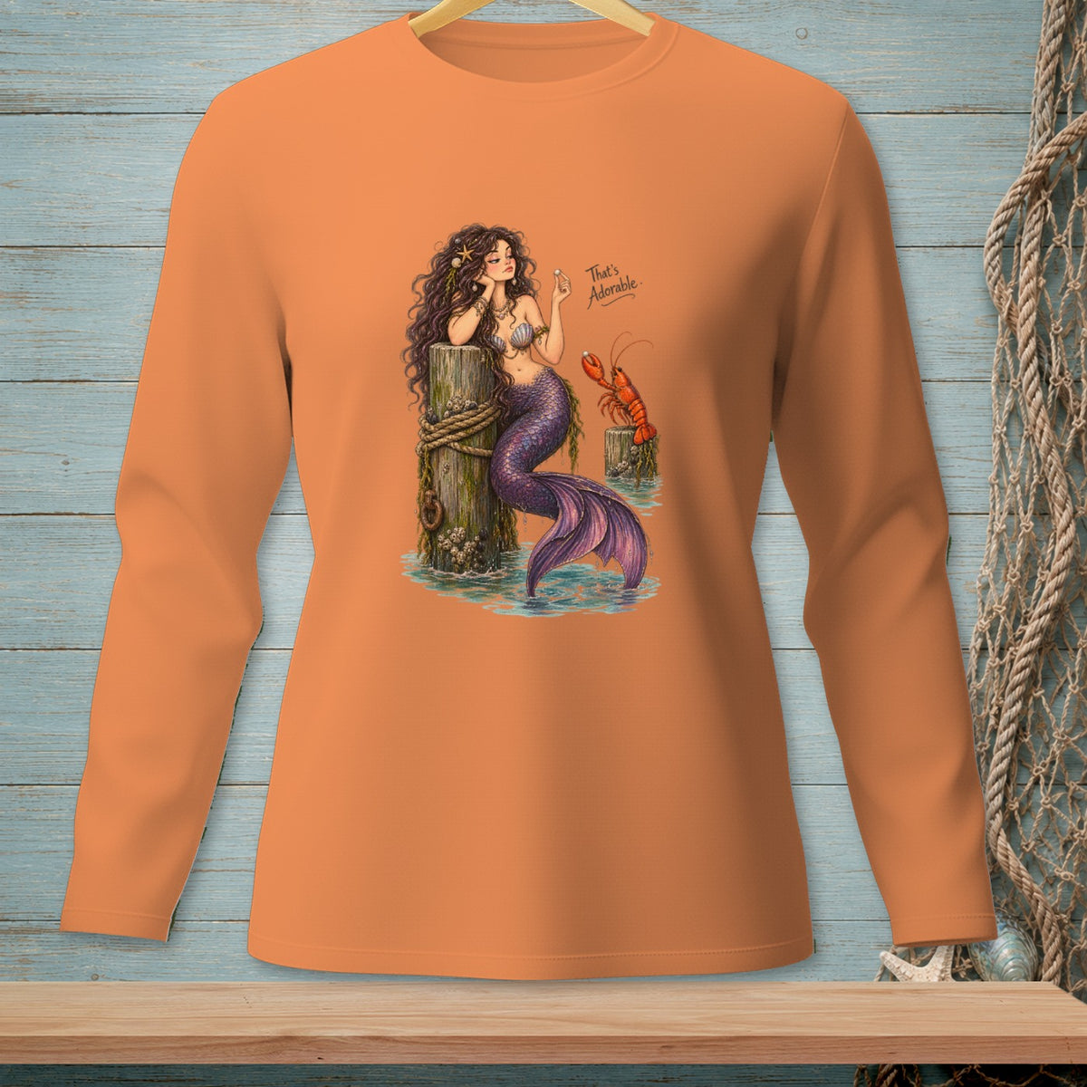 Mermaid with purple tail and lobster on a wooden post, text "That's Adorable."