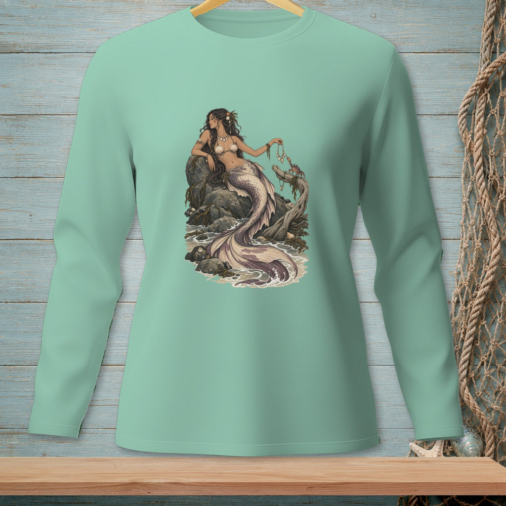 Mint long-sleeve shirt with a detailed mermaid illustration on a rocky seashore.