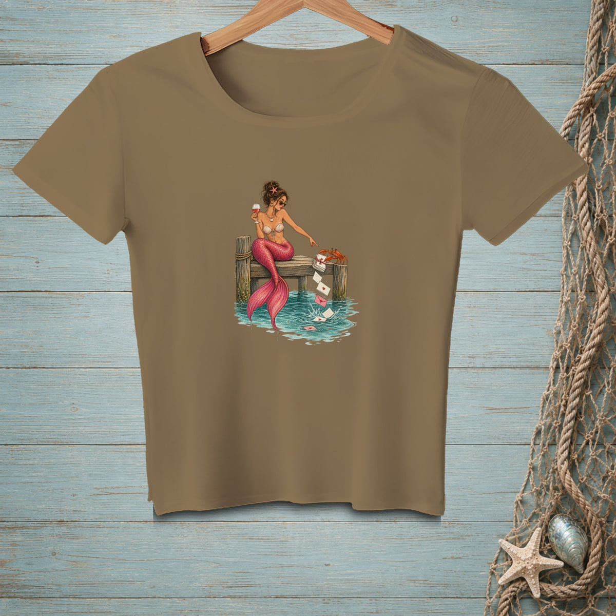 Brown t-shirt with a mermaid on a dock dropping letters into water.