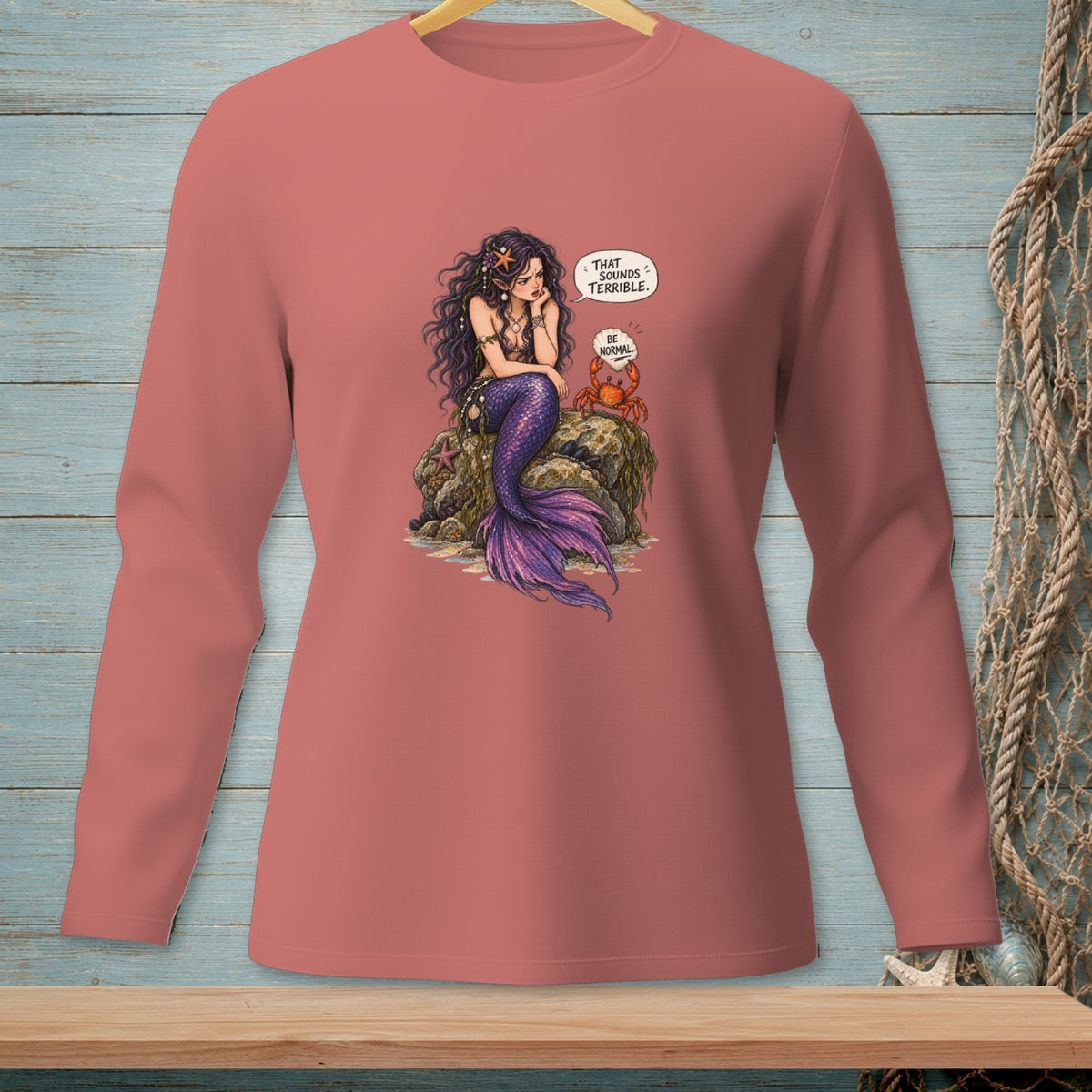 Mermaid on a rock with a crab saying "Be Normal."