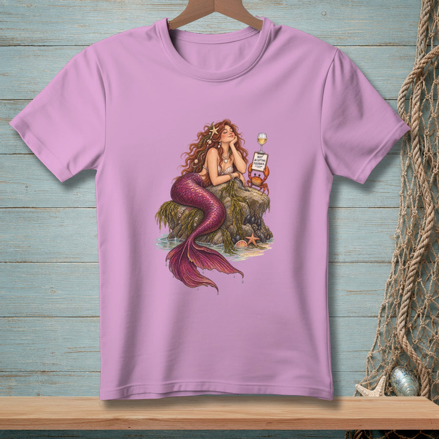 Mermaid with pink tail and brown hair reclines on a rock, a crab holds a sign that says "Not Accepting Feedback."