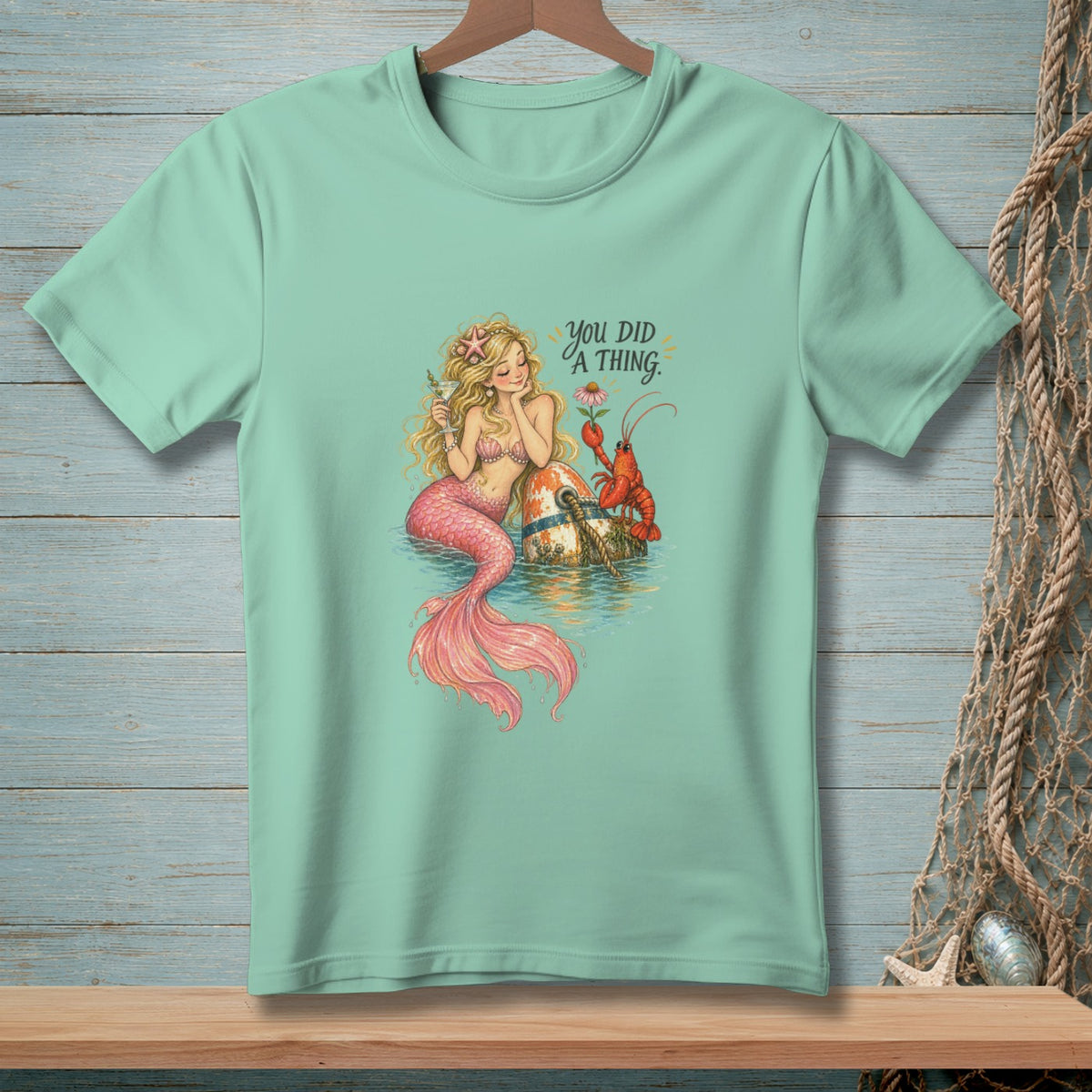 Mint green t-shirt with a mermaid and lobster graphic and text that reads "You did a thing."