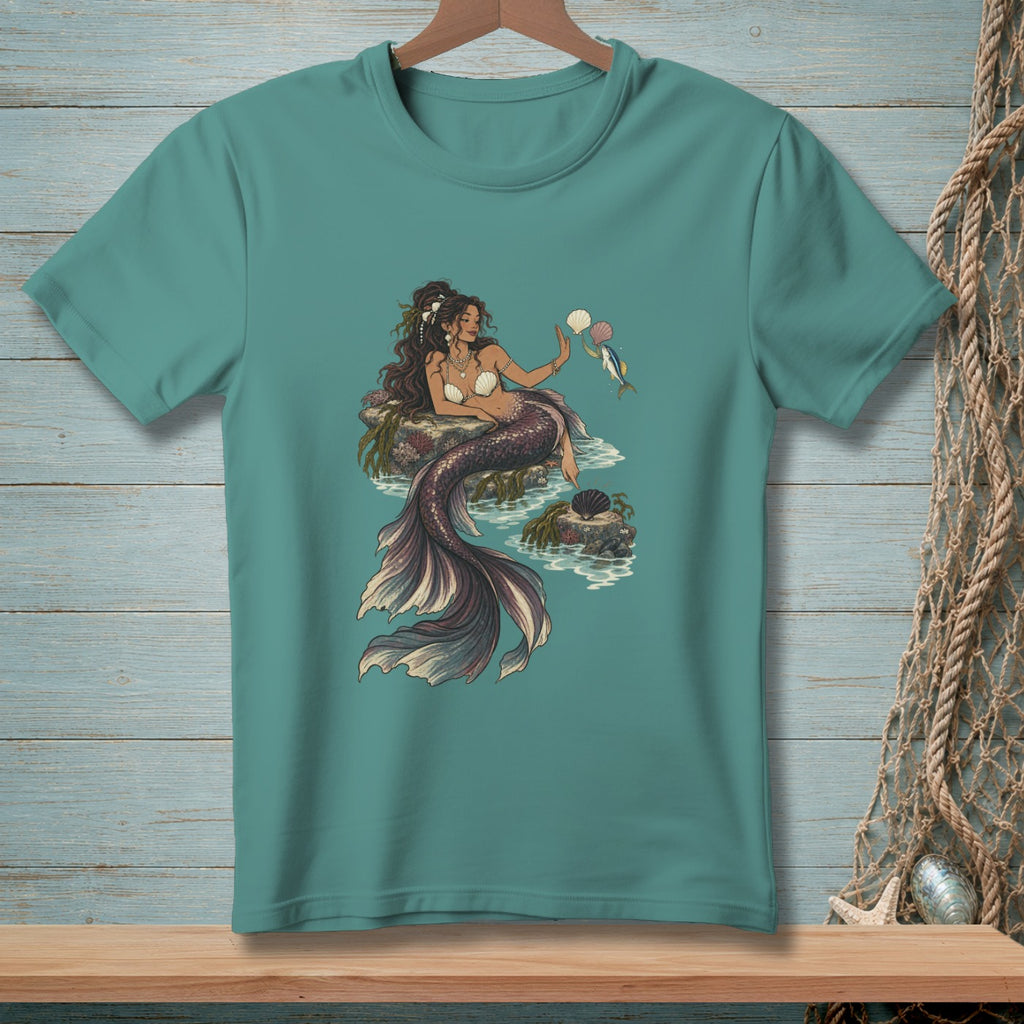 Mermaid sitting on rocks, holding seashells and a fish.