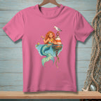 Pink t-shirt with cartoon mermaid, fish, seagull, and buoy.
