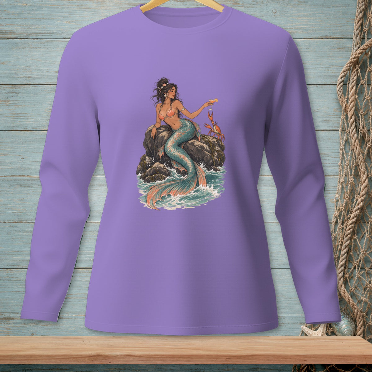 Purple long-sleeve shirt with mermaid, crab, and ocean graphic on a rock.