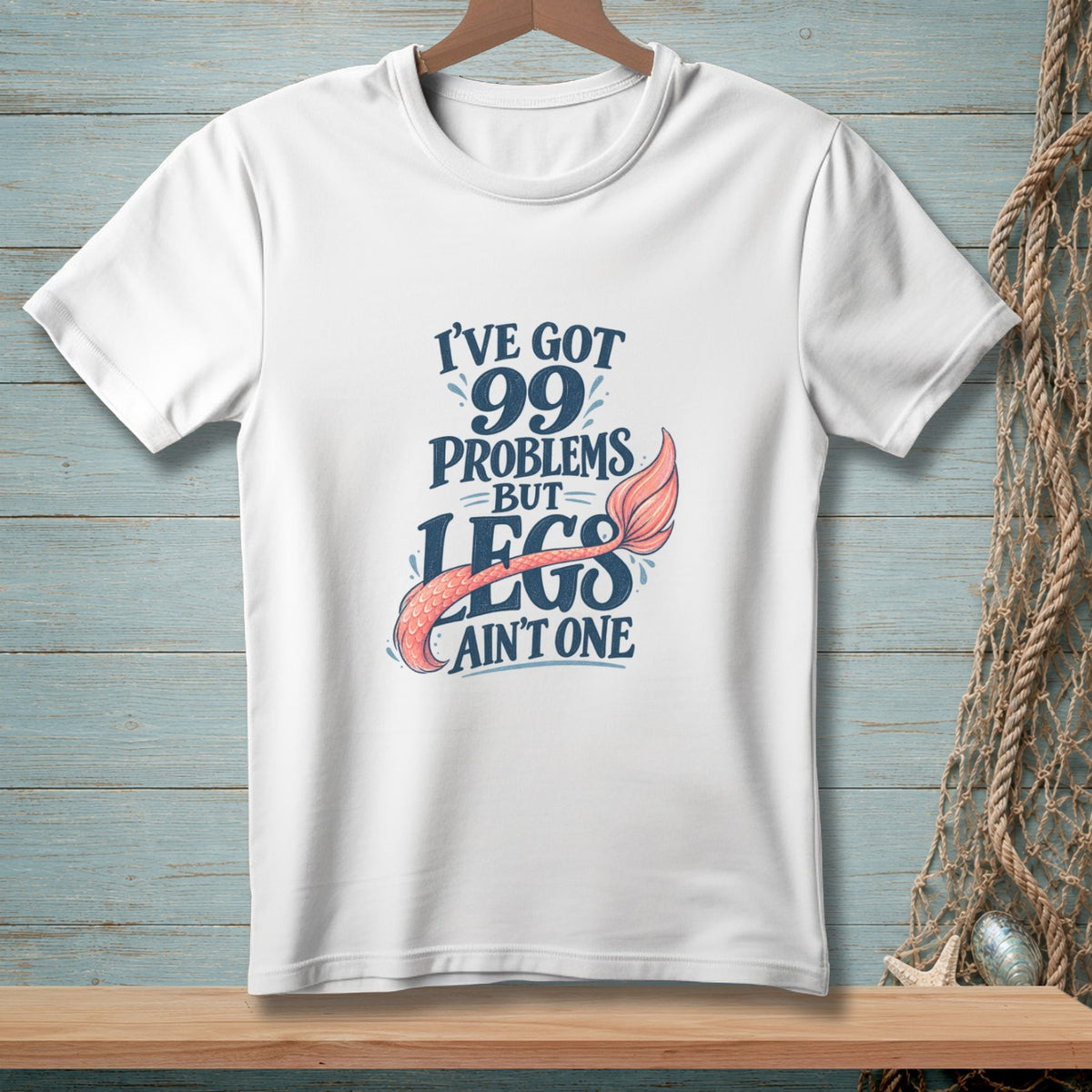 White t-shirt with text "I've got 99 problems but legs ain't one" and a mermaid tail.