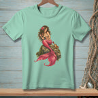 Mint t-shirt with a mermaid and crab illustration on a rock.