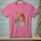Two mermaids with colorful tails sit on a wooden dock, one looking in a mirror.