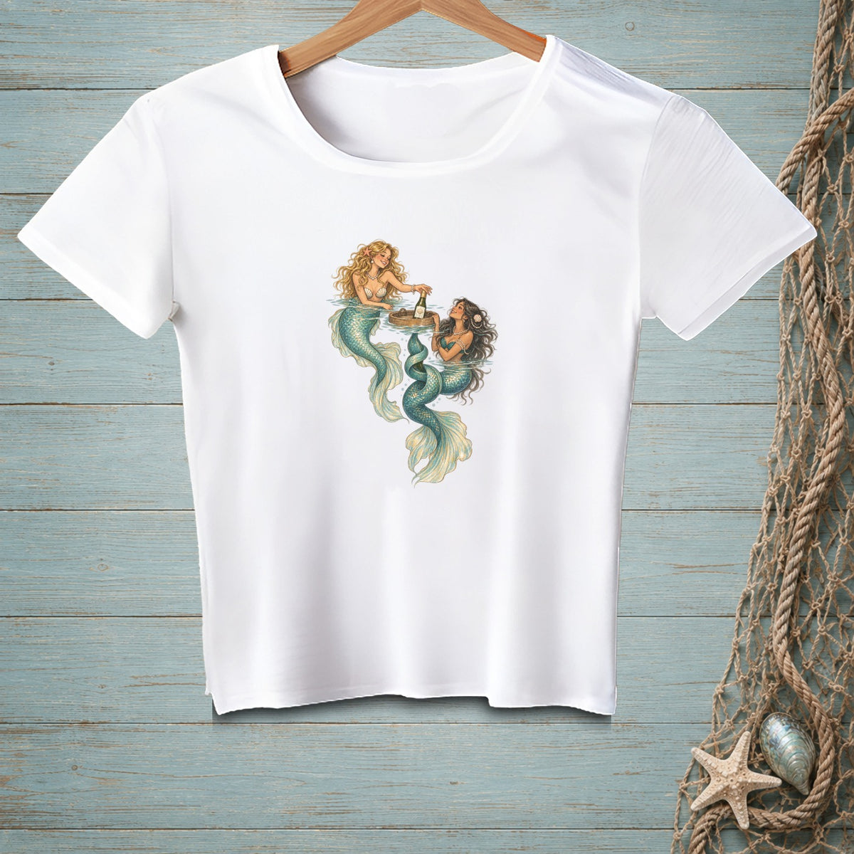 White t-shirt with graphic of two mermaids enjoying drinks in water.