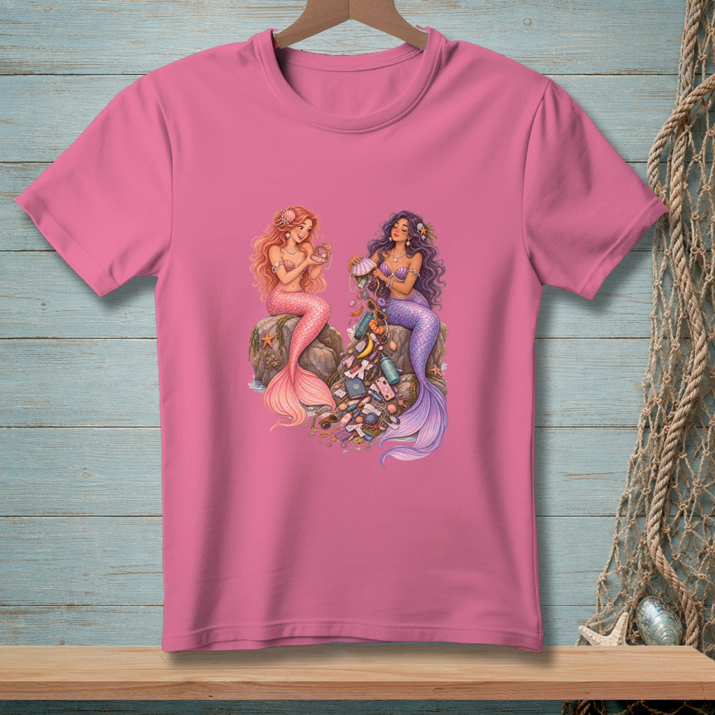 Two mermaids sit on rocks surrounded by a pile of collected treasures and ocean trash.
