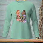 Two mermaids sitting on rocks surrounded by sea trash, on a mint green shirt.