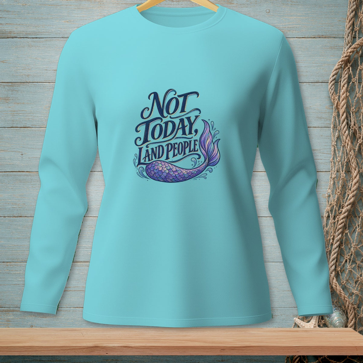 Turquoise long-sleeved shirt with "Not Today Land People" text and mermaid tail graphic.