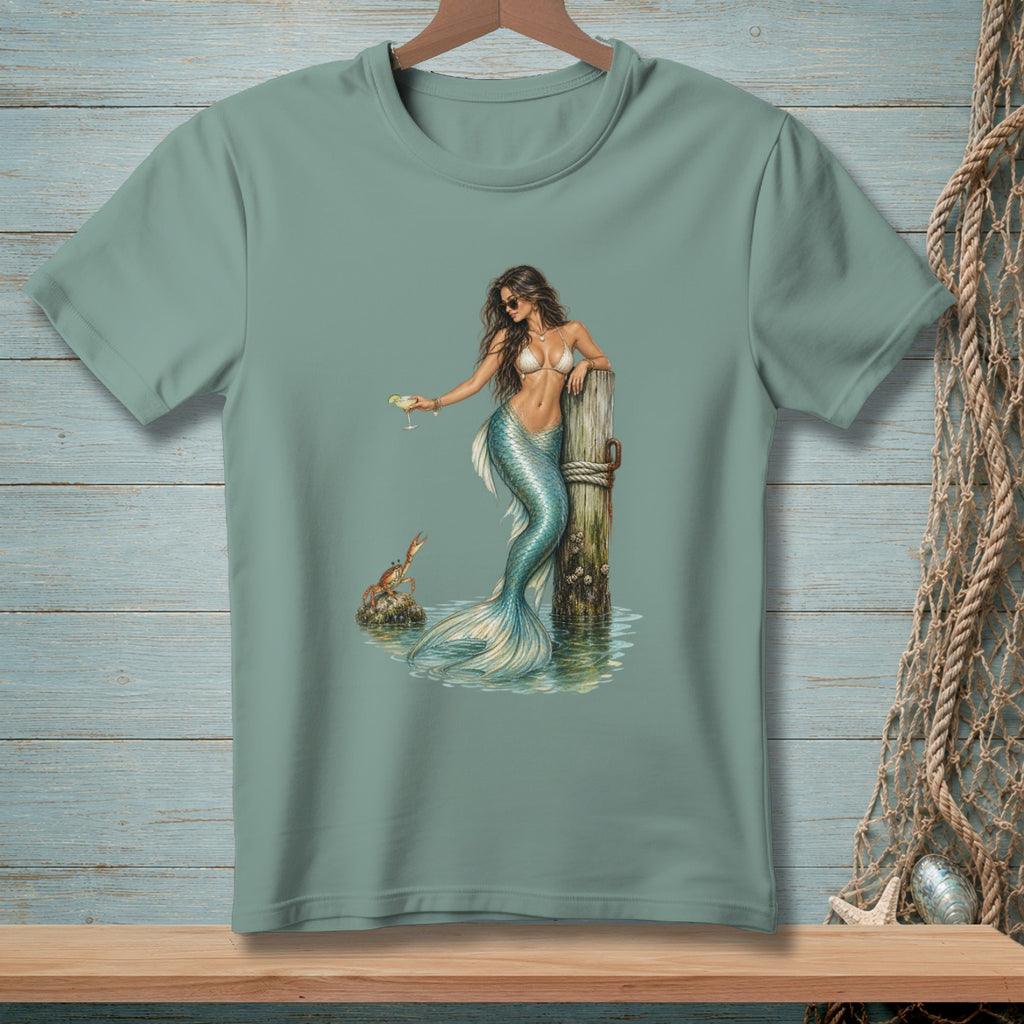 T-shirt graphic of a mermaid holding a drink, leaning on a wooden post.