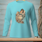 Mermaid reading a book on rocks with crabs and waves, on a blue shirt.